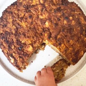 Image of toddler reaching for a slice of coconut and carrot bread. Recipe by Lunch Lady Lou